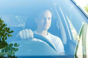 portrait de un Beau gars conduite le sien voiture photo