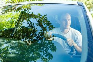 portrait de un Beau gars conduite le sien voiture photo