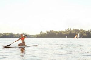 action coup de Jeune femme sur pagayer planche photo