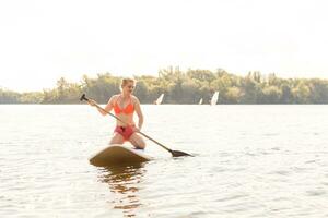 action coup de Jeune femme sur pagayer planche photo