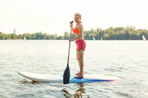 action coup de Jeune femme sur pagayer planche photo