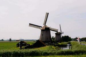 Moulins à vent sont dans le milieu de une champ photo