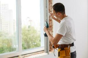 Masculin industriel constructeur ouvrier à fenêtre installation dans bâtiment construction site photo