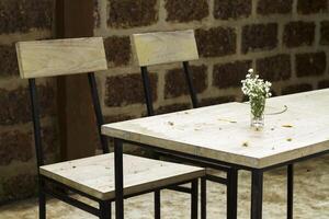 verre avec des fleurs sur une table en bois vintage