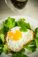 un frit Oeuf avec Roquette et salade dans une assiette photo