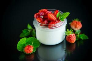 sucré fait maison yaourt avec Frais mûr des fraises dans une verre pot photo