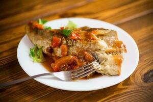 entier poisson merlu cuit avec carottes, betteraves, poivrons et autre photo