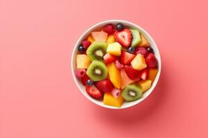 ai généré bol de en bonne santé Frais fruit salade sur rose arrière-plan, Haut voir. génératif ai. photo