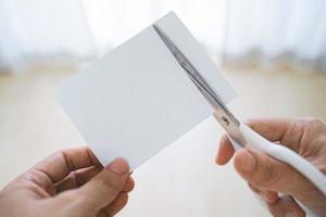 deux mains coupant du papier avec des ciseaux photo