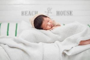 adorable nouveau-né dormant paisiblement sur une couverture blanche photo