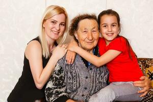 une multi génération portrait de une content grand-mère avec sa fille et petite fille dépenses temps ensemble photo