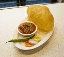 Indien cuisine cholé bature aussi connaître comme poussin pois curry, cholé bhture ou Chola, chana Masala servi avec frit puri est une plat de le punjab photo