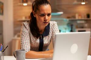 femme d'affaires squiter yeux car de épuisement tandis que travail sur une projet en retard à nuit de maison. employé en utilisant moderne La technologie à minuit Faire heures supplémentaires pour emploi, entreprise, carrière, réseau, mode de vie. photo