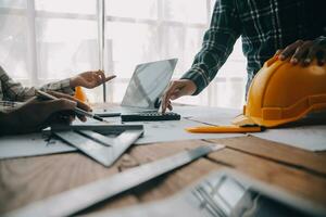 deux hommes d'affaires ingénieur de chantier. objets d'ingénierie sur le lieu de travail avec des partenaires interagissant en arrière-plan photo