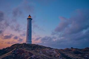 blanc phare dans le dunes de le danois Nord mer côte photo