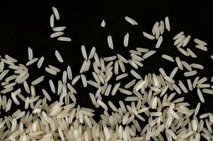 une pile de blanc riz sur une noir Contexte photo
