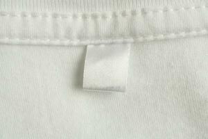 Vide blanc blanchisserie se soucier vêtements étiquette sur blanc chemise en tissu texture Contexte photo