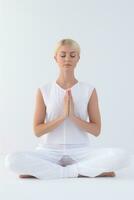 ai généré une femme dans blanc vêtements est séance dans une lotus position photo