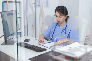 médical Personnel l'écriture Remarques sur presse-papiers séance à bureau dans hôpital bureau. soins de santé médecin spécialiste dans médicament fournir santé se soucier prestations de service traitement examen. photo