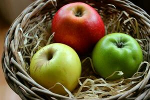 jaune, rouge et vert Pomme des fruits dans bois copeaux dans une osier pot fermer Stock photo