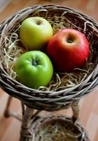 Frais coloré Pomme des fruits de différent variétés dans une osier panier avec en bois copeaux sur une rotin grille photo