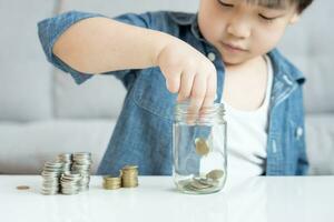 économiser de l'argent. les enfants mettent des pièces pour économiser. richesse, finance, assurance, investissement, éducation, avenir, planifier la vie, apprendre, banque, famille, santé, assurance maladie et accident. photo