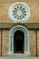 une église avec une grand rond fenêtre et une porte photo