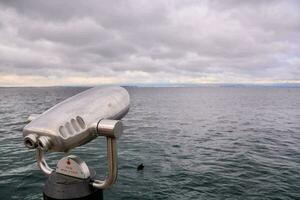 une argent binoculaire surplombant le océan photo