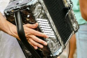 une homme en portant un accordéon dans le sien mains photo