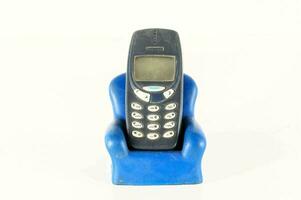 une bleu Plastique chaise avec un vieux téléphone portable dans il photo