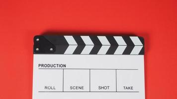 clap ou ardoise de cinéma. il utilise dans la production vidéo, le cinéma, l'industrie du cinéma sur fond rouge. photo