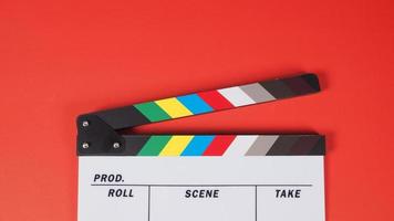 Clap ou ardoise de film sur fond rouge. Il est utilisé dans la production vidéo et l'industrie cinématographique. photo