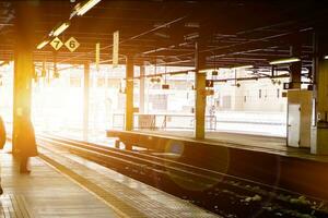 supporter ville, Japon, 2018 - neige flocons et la glace éclaboussure dans chemin de fer avec touristes sont attendre train dans supporter train Plate-forme avec Soleil éclater et lentille éclater à l'extérieur gare. photo
