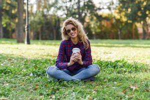 belle femme buvant du café dans le parc photo