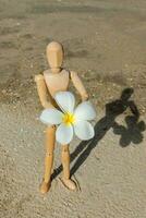 en bois des modèles donner une fleur sur le plage. photo