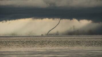 tornade frappe le l'eau de une assombri ciel photo