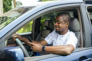 portrait de une Jeune noir africain Beau chauffeur dans Taxi voiture en utilisant intelligent téléphone La technologie photo