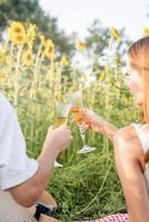 jeune couple, avoir, pique-nique, sur, champ tournesol, à, coucher soleil photo