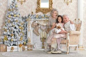 grands-parents avec petit enfant en train de préparer pour Noël ensemble photo