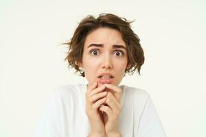 proche en haut de effrayé brunette femme, tremblement de craindre, à la recherche concerné et effrayé, permanent plus de blanc studio Contexte photo