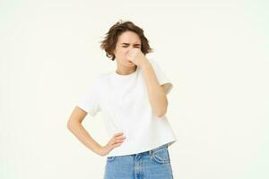 portrait de femme cette se ferme sa nez de affreux, répugnant odeur, quelque chose pue, des stands plus de blanc Contexte photo