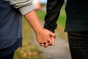 deux copines tenir mains sur une marcher. amitié, relation concept. photo