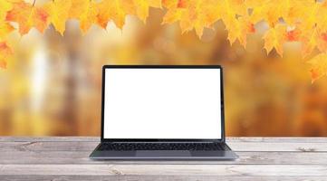 maquette d'ordinateur portable ouvert et feuilles d'érable jaune-orange photo