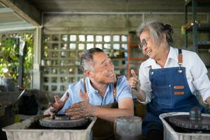 portrait de une Sénior asiatique couple Faire Activités ensemble dans le poterie atelier. photo