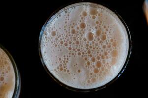 Haut vue sur verre de Bière avec bulle mousse photo