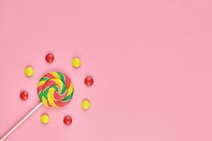 sucette sucrée et bonbons sur fond rose photo