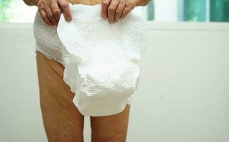 asiatique Sénior femme patient portant adulte incontinence couche tampon dans hôpital. photo