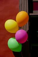 coloré des ballons pendaison de une rouge mur photo