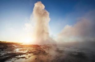 fantastique éruption du geyser de strokkur au coucher du soleil en islande. couleurs fantastiques photo