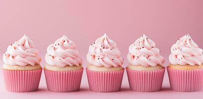 ai généré petits gâteaux avec rose Glaçage sont dans une rangée sur une rose Contexte photo